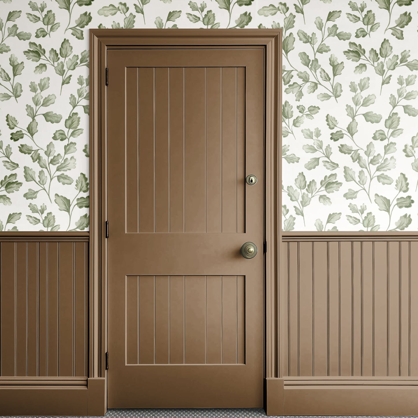 Brown door with gold handle against a floral wallpapered wall