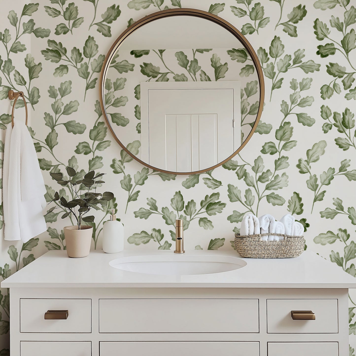 Bathroom with green leafy wallpaper, round mirror, and white vanity.