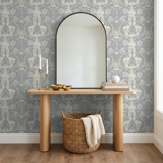 Floral wallpaper with honeysuckle pattern in cool tones in a room with a wooden console and mirror.
