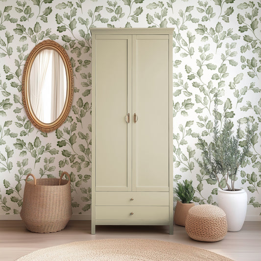 Beige wardrobe with decorative plants and a round mirror in a room with leaf-patterned wallpaper.