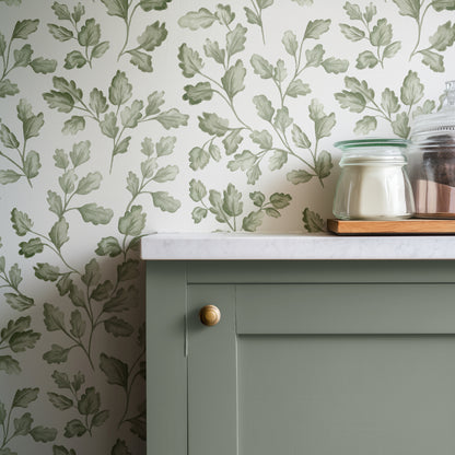 Green cabinet with white countertop against a leaf-patterned wall