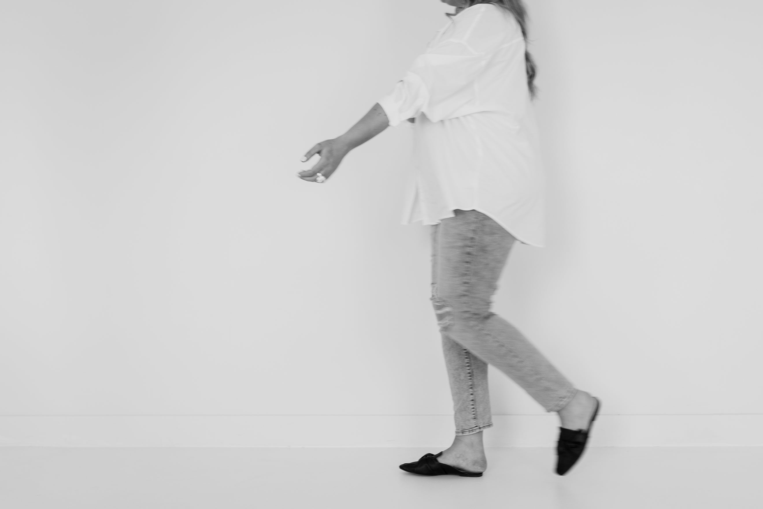 Sabina Maria wearing a white outfit with gray pants on a plain background