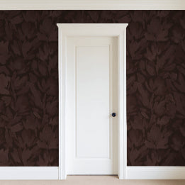 Burgundy brown floral wallpaper with tulip vines in a room with a white door.