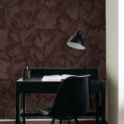 Burgundy brown floral wallpaper in a modern home office with black desk and lamp.