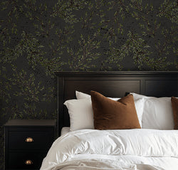 Charcoal wallpaper with green leaf branches in modern bedroom setting.