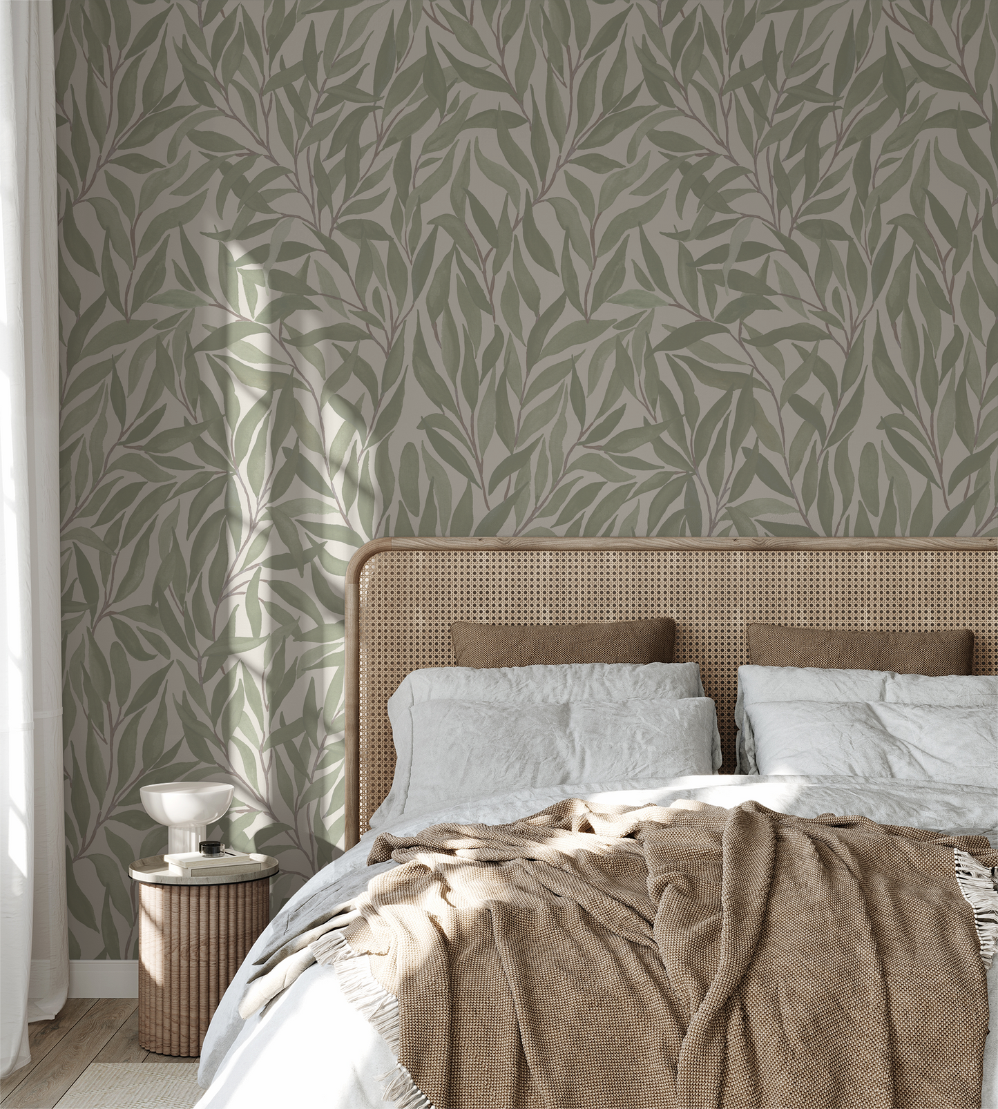 Green leaf pattern wallpaper in a cozy bedroom setting with neutral decor.