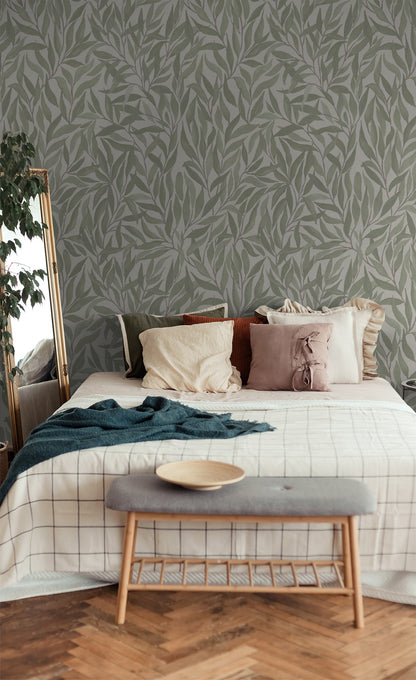 Green leaf pattern wallpaper in cozy bedroom with pillows and bench