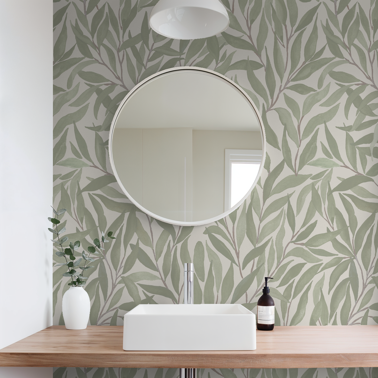 Green leaf patterned wallpaper in modern bathroom with round mirror and wooden vanity.