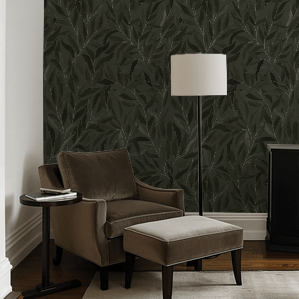 Living room with brown armchair, ottoman, and floor lamp against a dark leaf-patterned wall.