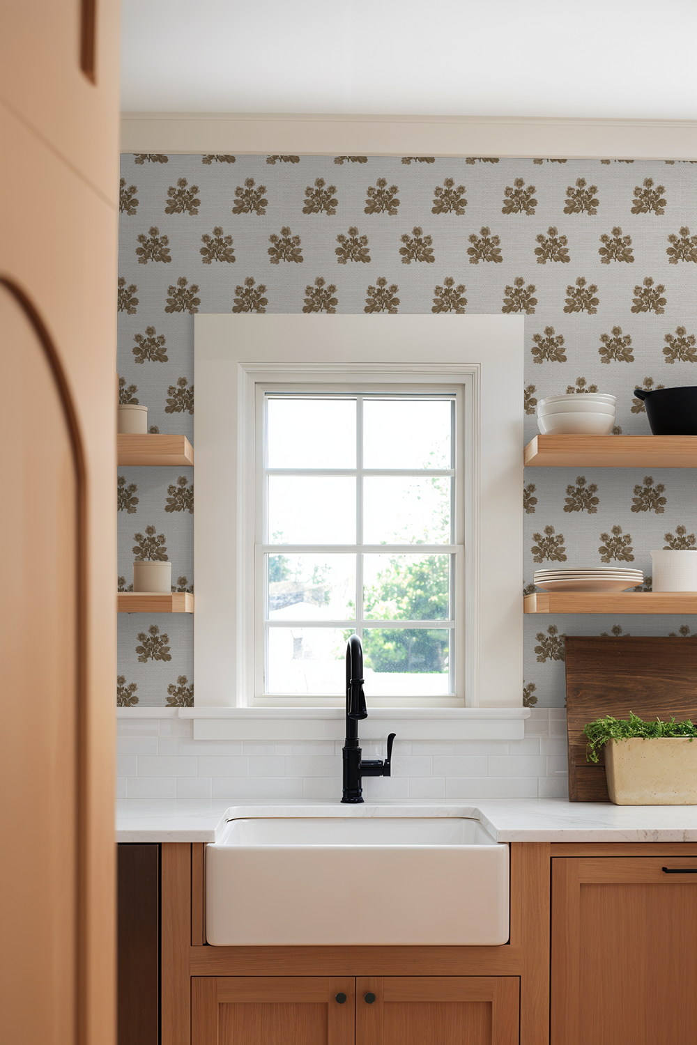 Musky brown floral wallpaper in a cozy kitchen with wooden shelves and sink.